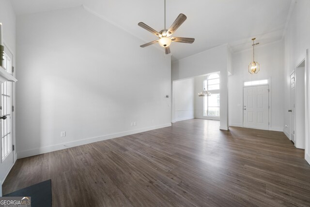 3047 Standing Rock Ct, Lithia Springs, GA 30122 - unfurnished living room with ceiling fan with notable chandelier, baseboards, high vaulted ceiling, and dark wood-style flooring