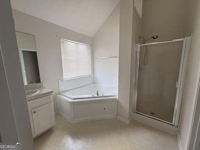 bathroom featuring vanity, vaulted ceiling, a stall shower, and a garden tub