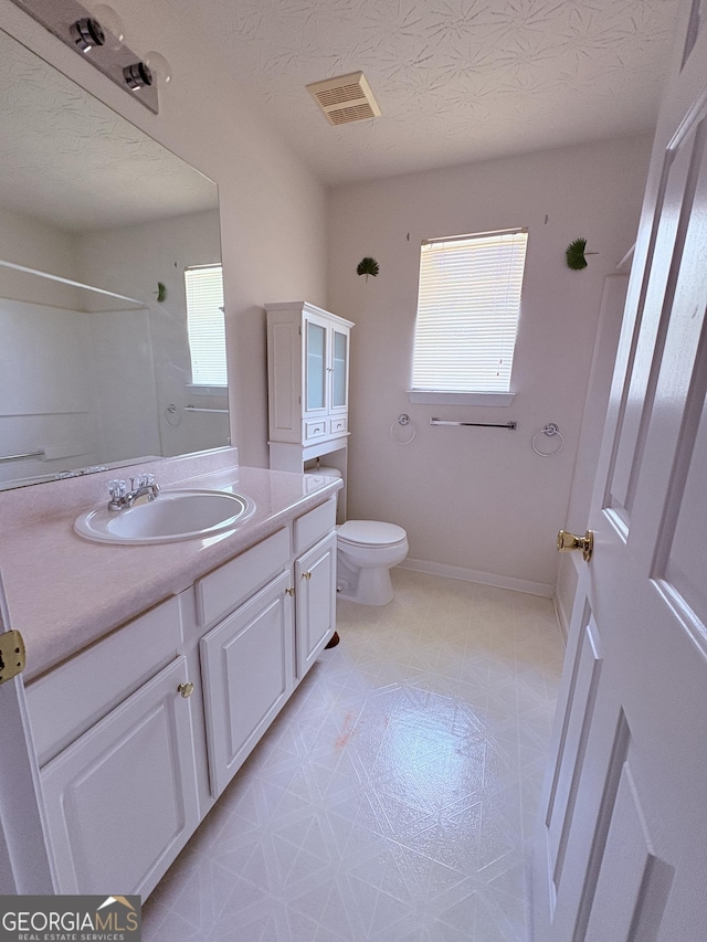 bathroom with vanity, visible vents, toilet, baseboards, and tile patterned floors