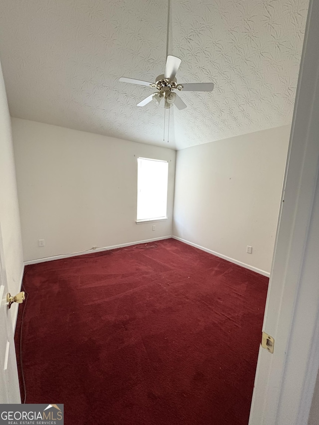 spare room with baseboards, a textured ceiling, ceiling fan, and carpet