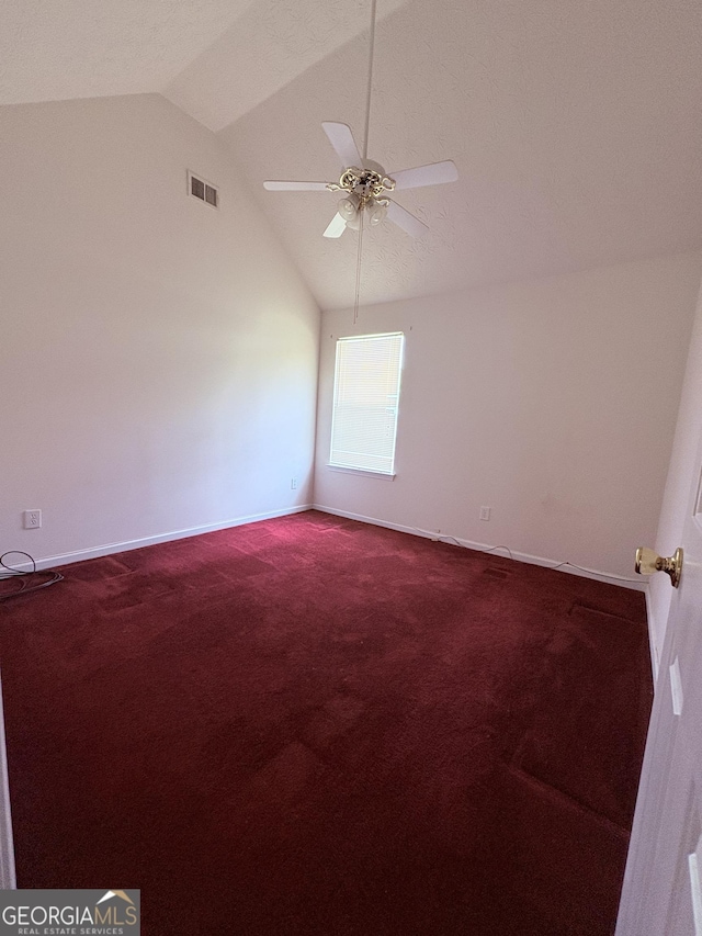 unfurnished room with a ceiling fan, dark carpet, and lofted ceiling
