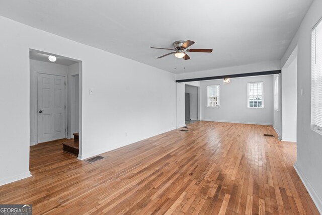 unfurnished living room with visible vents, light wood finished floors, ceiling fan, and baseboards