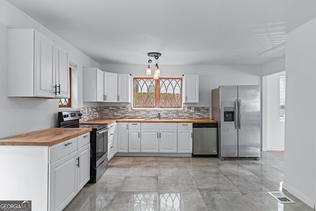 kitchen featuring wood counters, plenty of natural light, stainless steel appliances, and visible vents