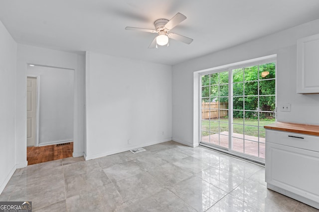 interior space with visible vents, a ceiling fan, and baseboards