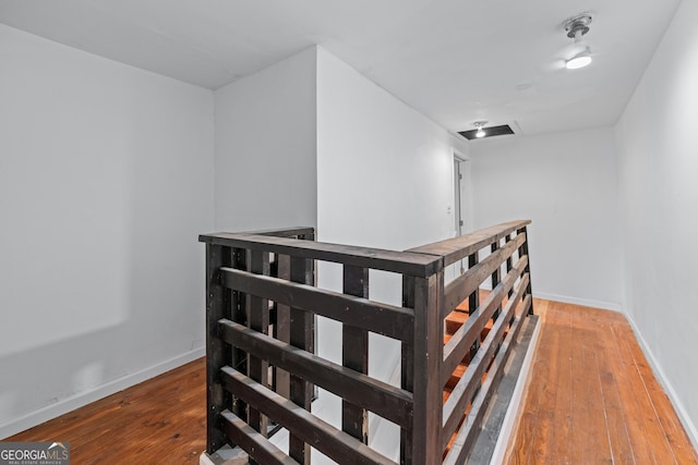 staircase featuring baseboards and hardwood / wood-style floors