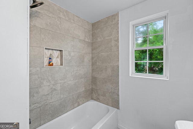 bathroom with a washtub, toilet, walk in shower, and baseboards