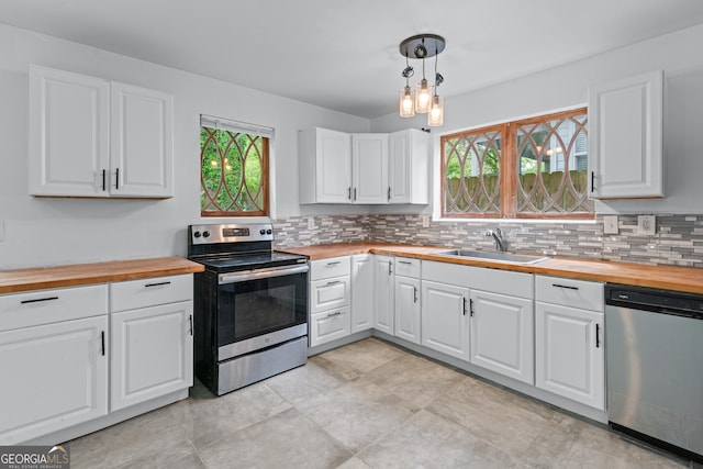 kitchen featuring backsplash, stainless steel appliances, wood counters, and a sink