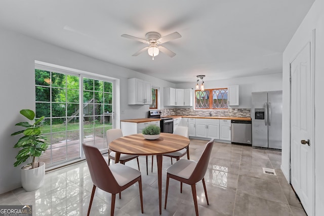 dining space featuring visible vents and ceiling fan with notable chandelier
