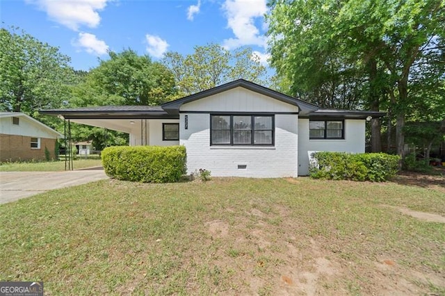 ranch-style house with brick siding, an attached carport, a front yard, and concrete driveway