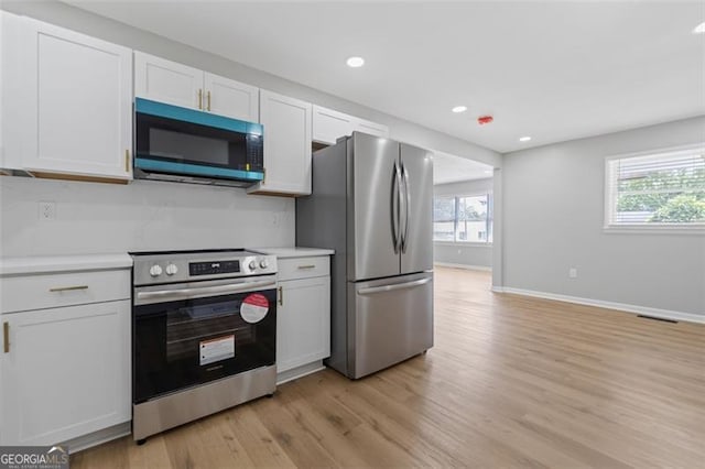 kitchen with stainless steel appliances, light countertops, baseboards, and a healthy amount of sunlight