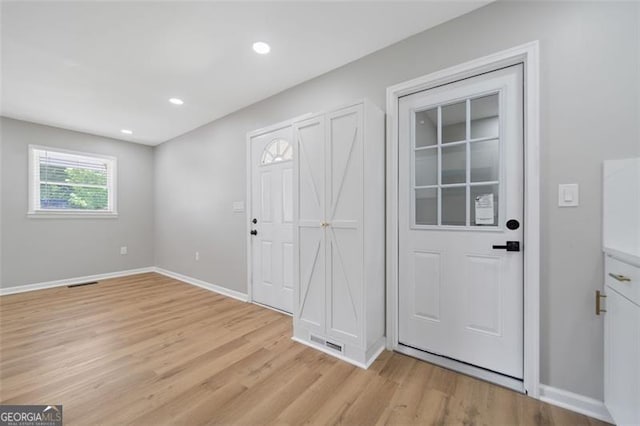 foyer with light wood-type flooring, baseboards, recessed lighting, and visible vents