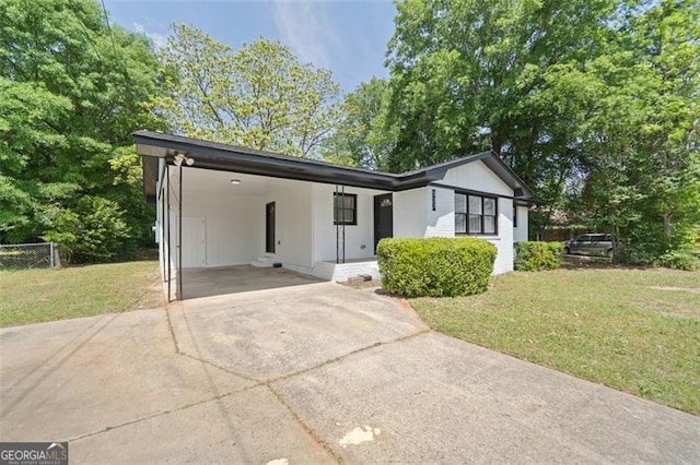 ranch-style house with driveway, a front lawn, fence, and a carport