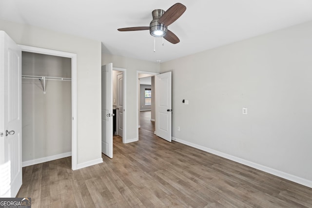 unfurnished bedroom with light wood-style flooring, baseboards, a closet, and ceiling fan