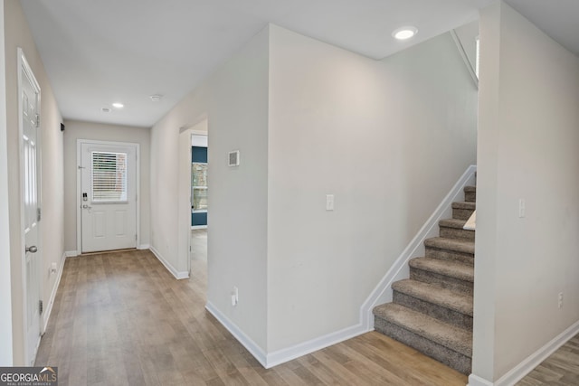 entryway featuring recessed lighting, light wood-type flooring, baseboards, and stairway