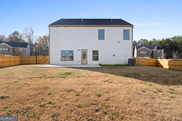 rear view of property with a fenced backyard, central AC unit, a patio area, and a lawn