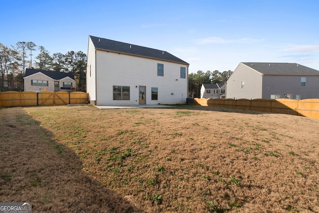 rear view of house featuring a yard, a patio area, and a fenced backyard