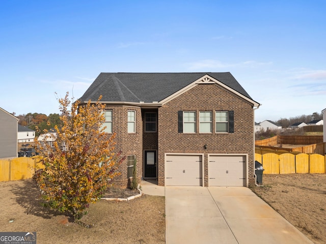 view of front facade featuring fence, roof with shingles, driveway, brick siding, and a garage