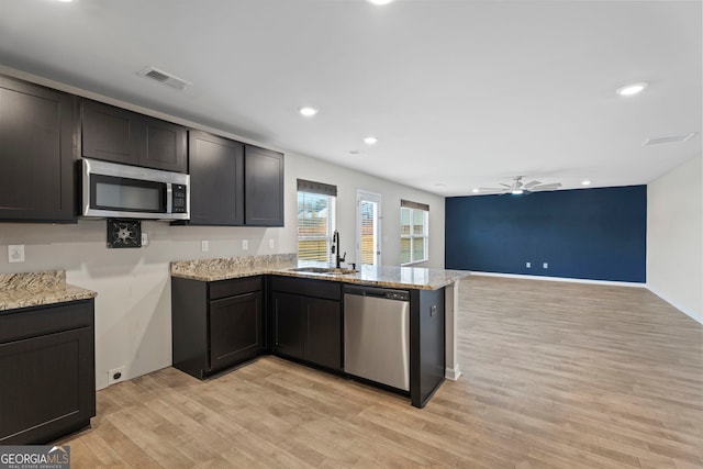 kitchen with a ceiling fan, a sink, stainless steel appliances, a peninsula, and visible vents