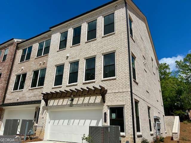 view of building exterior featuring an attached garage and concrete driveway