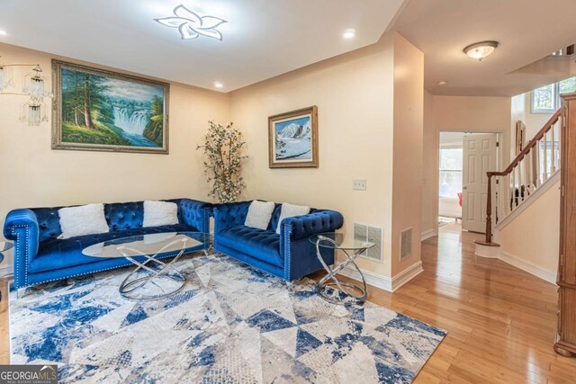 4319 Silver Peak Pkwy, Suwanee, GA 30024 - living area featuring baseboards, visible vents, light wood-style floors, and stairs