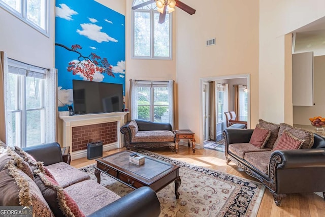 4319 Silver Peak Pkwy, Suwanee, GA 30024 - living area featuring a fireplace, visible vents, a ceiling fan, and a high ceiling