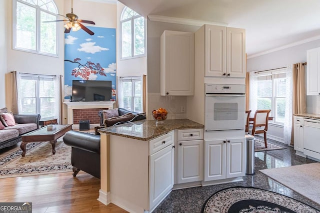 4319 Silver Peak Pkwy, Suwanee, GA 30024 - kitchen featuring white cabinets, ornamental molding, white appliances, open floor plan, and ceiling fan