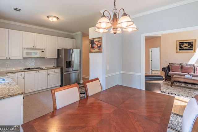 4319 Silver Peak Pkwy, Suwanee, GA 30024 - unfurnished dining area featuring baseboards, ornamental molding, a chandelier, and visible vents