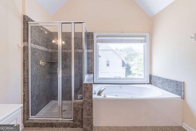 4319 Silver Peak Pkwy, Suwanee, GA 30024 - bathroom with vaulted ceiling, a tub with jets, tile patterned floors, and a stall shower
