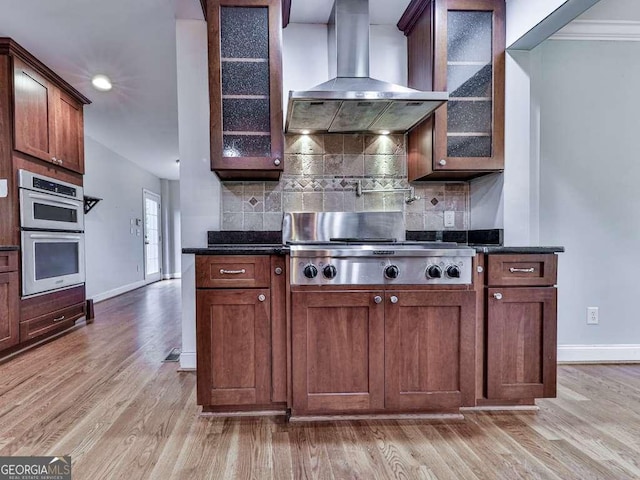 kitchen featuring double oven, wood finished floors, visible vents, and baseboards