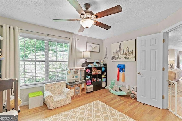 5566 River Heights Xing SE, Marietta, GA 30067 - recreation room featuring a wealth of natural light, a ceiling fan, wood finished floors, and a textured ceiling