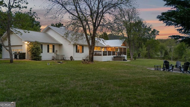 2180 Pine Lake Rd, Hiawassee, GA 30546 - rear view of house featuring a chimney, a sunroom, a yard, and a garage