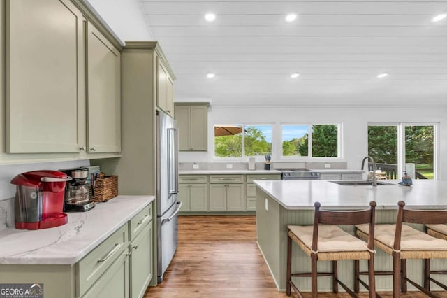 2180 Pine Lake Rd, Hiawassee, GA 30546 - kitchen with a breakfast bar, high quality fridge, a sink, and green cabinetry