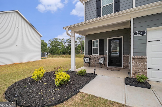 231 Limestone Cir, Conyers, GA 30013 - property entrance with a lawn, brick siding, a garage, and covered porch