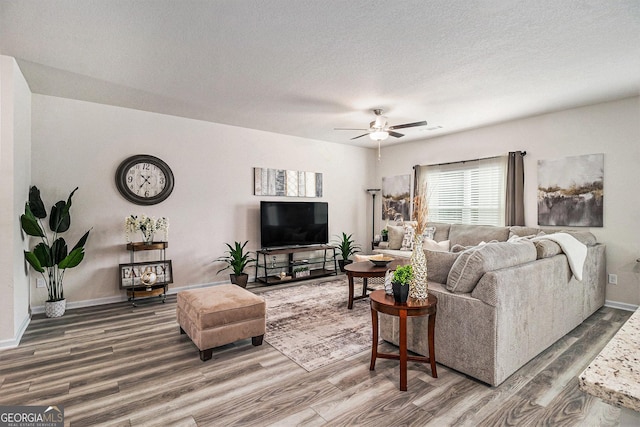 231 Limestone Cir, Conyers, GA 30013 - living room featuring baseboards, a ceiling fan, wood finished floors, and a textured ceiling