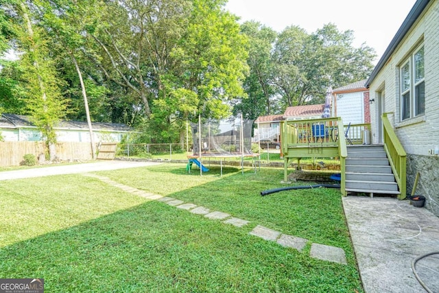 98 Chappell Rd NW, Atlanta, GA 30314 - view of yard with a trampoline, a fenced backyard, stairway, and a deck