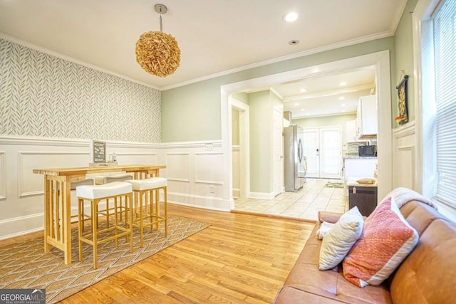 98 Chappell Rd NW, Atlanta, GA 30314 - dining room featuring wallpapered walls, a decorative wall, crown molding, wainscoting, and light wood-style flooring