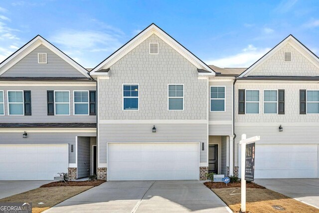multi unit property featuring an attached garage and driveway