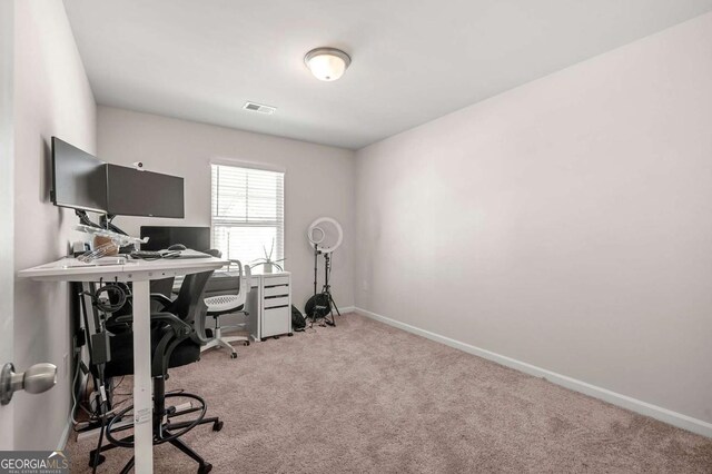 carpeted office with baseboards and visible vents