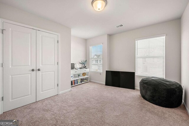 living area with visible vents, baseboards, and carpet floors