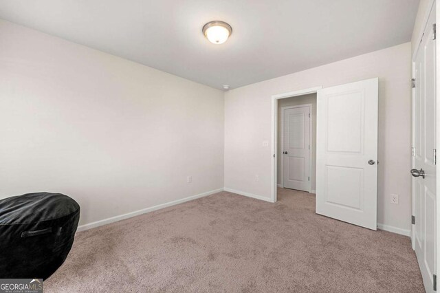 unfurnished bedroom with baseboards and light colored carpet