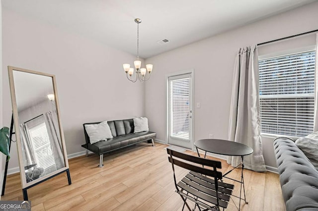 sitting room with a healthy amount of sunlight, a chandelier, visible vents, and light wood-style flooring