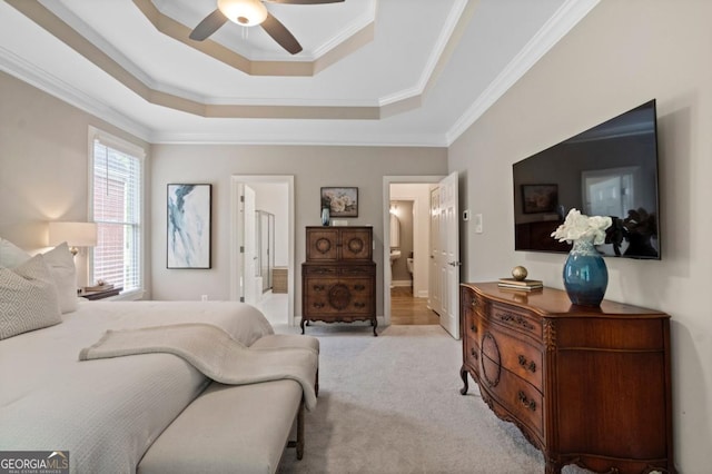 bedroom featuring crown molding, ceiling fan, a raised ceiling, ensuite bath, and carpet