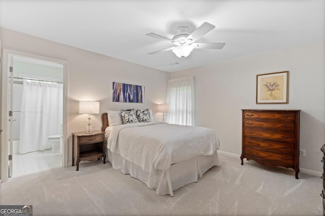 bedroom featuring baseboards, ensuite bathroom, a ceiling fan, and carpet flooring