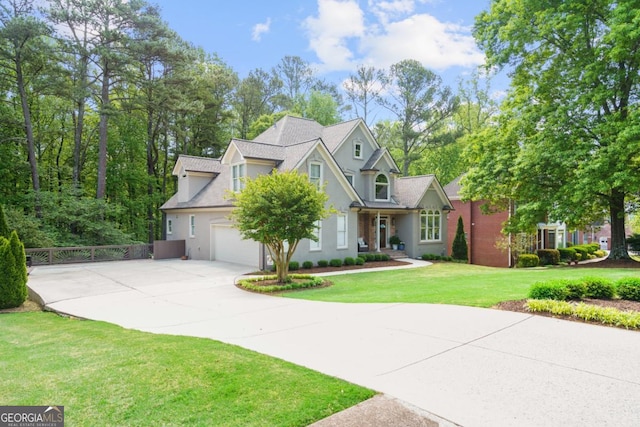 view of front facade with concrete driveway, stucco siding, fence, and a front lawn