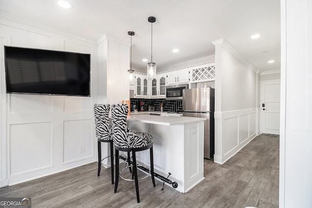 215 Piedmont Ave NE Unit 2210, Atlanta, GA 30308 - kitchen with light countertops, a decorative wall, a peninsula, glass insert cabinets, and appliances with stainless steel finishes