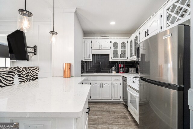 215 Piedmont Ave NE Unit 2210, Atlanta, GA 30308 - kitchen featuring white cabinetry, glass insert cabinets, decorative backsplash, wood finished floors, and appliances with stainless steel finishes