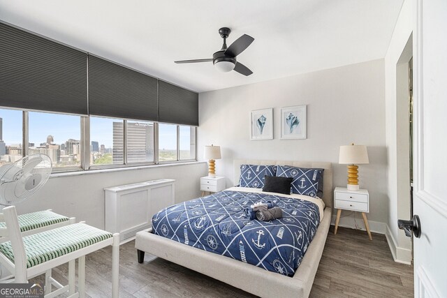 215 Piedmont Ave NE Unit 2210, Atlanta, GA 30308 - bedroom with wood finished floors, baseboards, ceiling fan, and a view of city