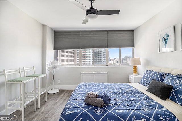 215 Piedmont Ave NE Unit 2210, Atlanta, GA 30308 - bedroom featuring a city view, wood finished floors, a ceiling fan, and baseboards