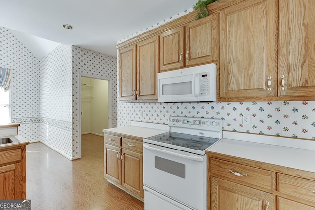 kitchen with white appliances, wallpapered walls, light wood-style floors, light countertops, and baseboards