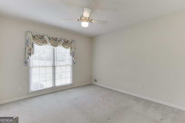 carpeted spare room with healthy amount of natural light, baseboards, and a ceiling fan